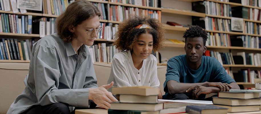 White male student, Black female student with headband, Black male in library