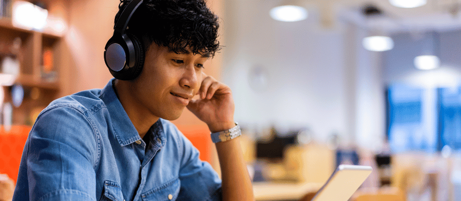 Young man wearing headphones while sitting at a table