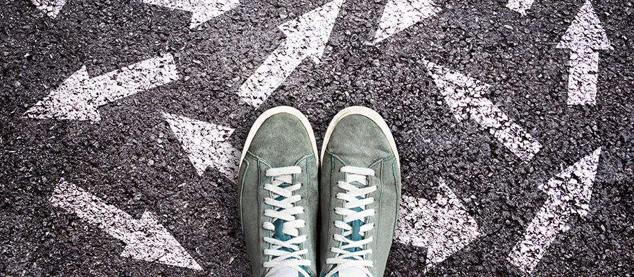 Grey-green sneakers on payment with arrows facing haphazardly in all directions