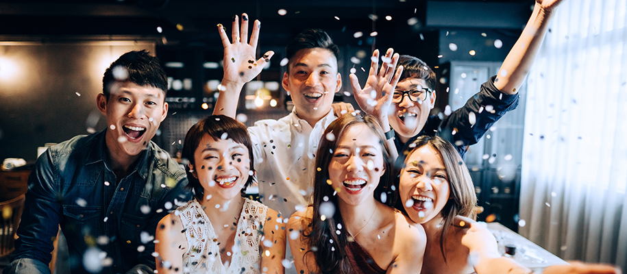 Group of Asian people dressed up for a party, throwing confetti with hands in ai