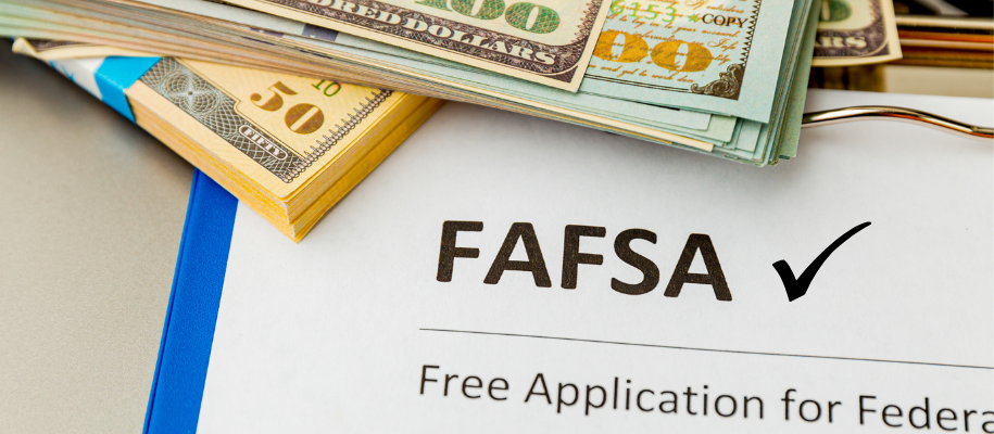 Piles of money on top of paper on clipboard that reads FAFSA with a checkmark