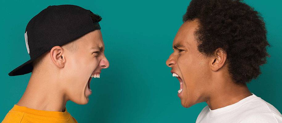 White male in backwards cap and Black male with curly hair yelling at each other