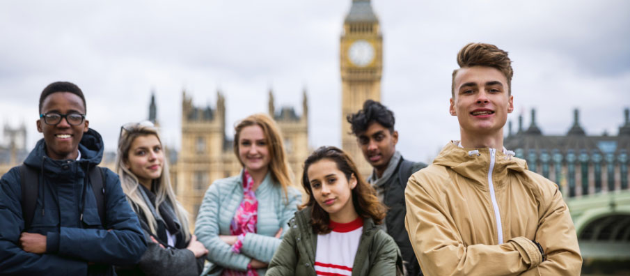 Group of college students posing in front of Big Ben & Parliament in London