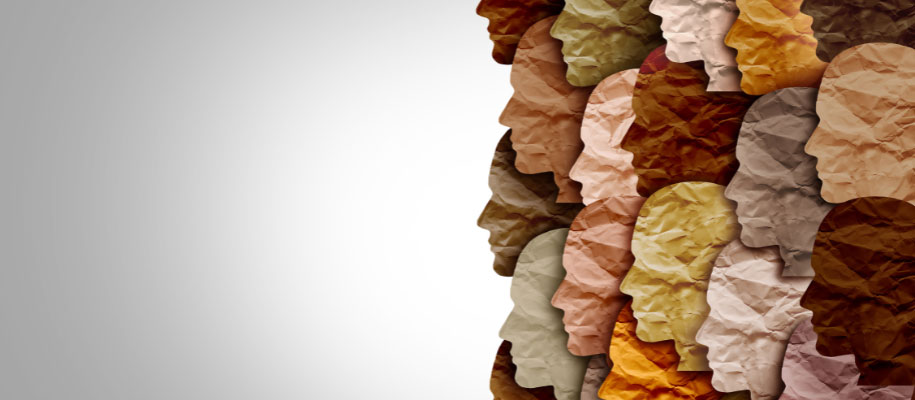 Layers of wrinkled paper face silhouettes in many colors representing diversity