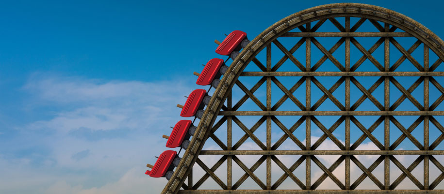 3D rendering of wooden roller coaster with red seats going uphill against sky