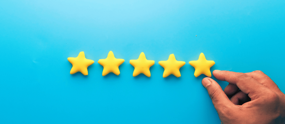 A hand places five stars