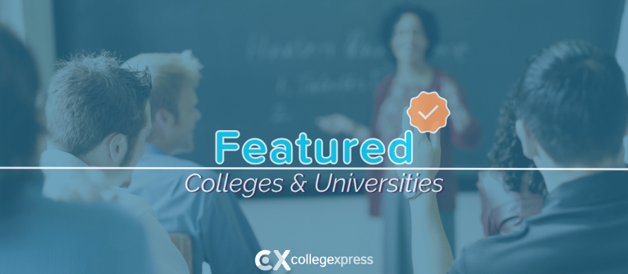 Students sit facing instructor teaching at a chaulkboard