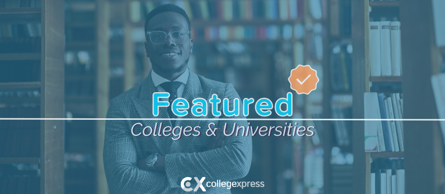 Black man in glasses, suit in library against shelves, featured schools logo