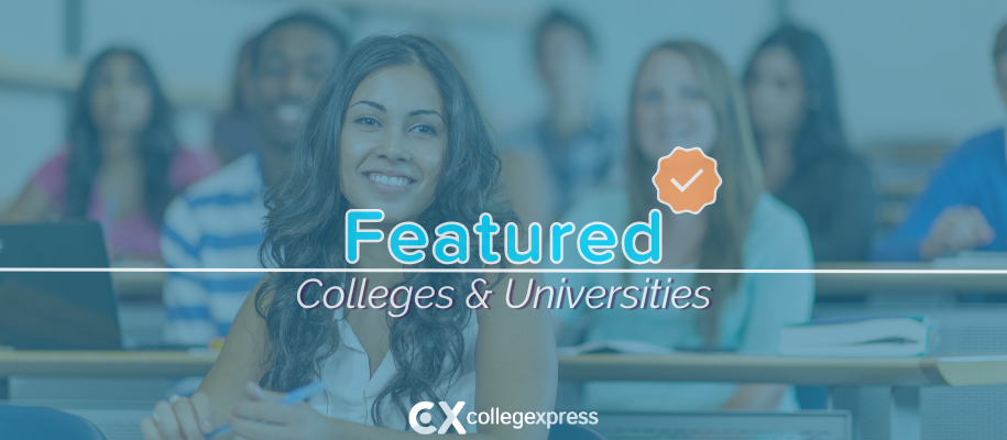 Latina woman in white smiling in lecture hall of students, featured school logo