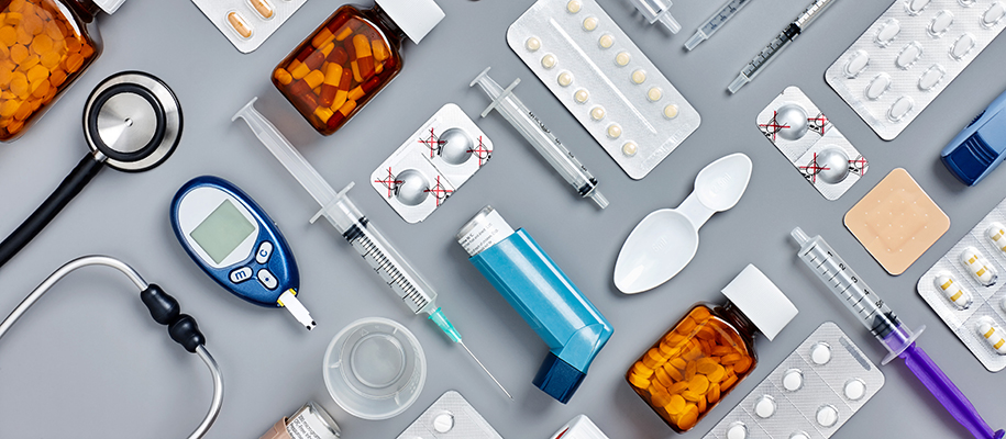 Various medical supplies laid out in a grid on gray backdrop