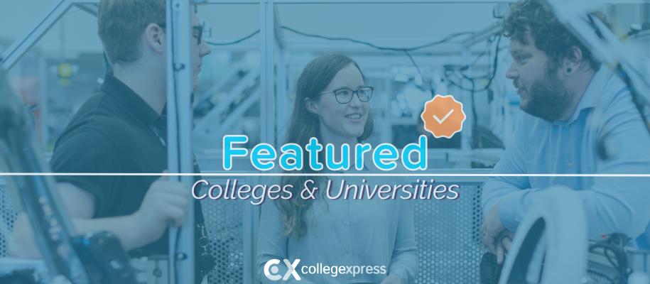 Two men, woman standing in workshop next to metal vehicle, featured schools logo