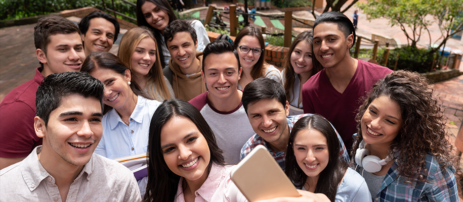 Group of Hispanic/Latino people taking a big group selfie outside