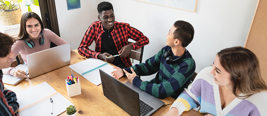 Small group of diverse students working together in small study room on campus