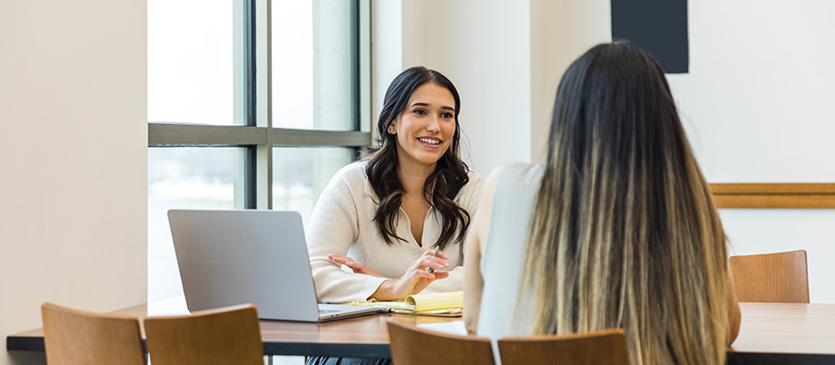 Young Hispanic female college admission counselor meeting with student