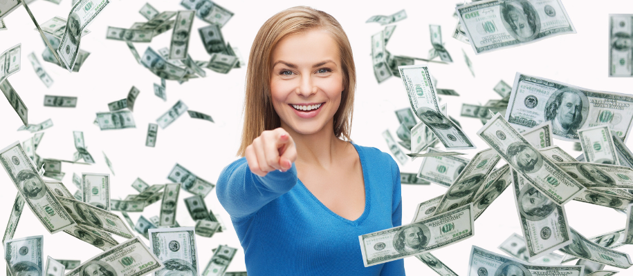 White blond woman in blue sweater pointing at camera, money falling around her