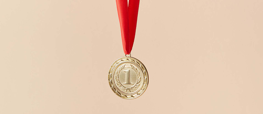 Gold medal with a 1 on red ribbon, light pink background