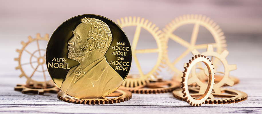 Nobel prize standing on size surrounded by gold cogs laying down and standing up