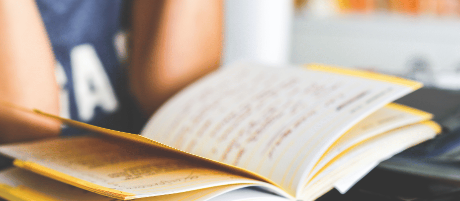 Close up photo of an open textbook with lots of text highlighted in yellow