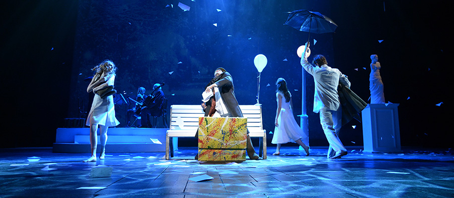 Group of young actors on a stage in a play under blue lighting