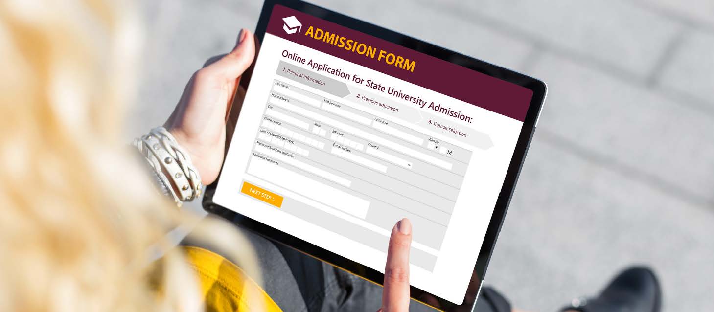 Over shoulder shot of blond woman using tablet to fill in college application