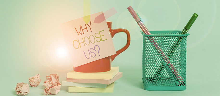 Red mug on stack of sticky notes, note on it reading "Why choose us," pen holder