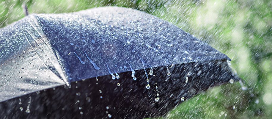 Open black umbrella getting rained on