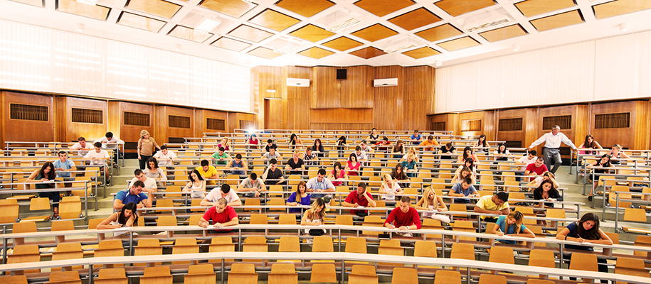 Two professors supervising lecture hall of students taking an exam