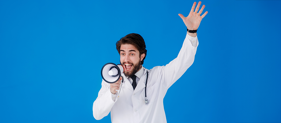 White male doctor in lab coat with stethoscope yelling into mini megaphone