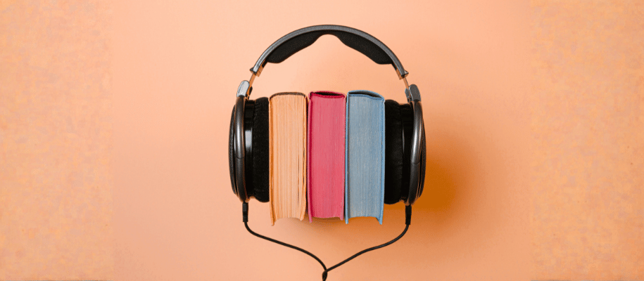 Three books placed between the earpieces of headphones