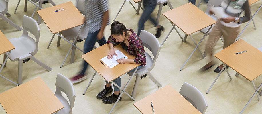Woman in colorful shirt working on test will students get up around her