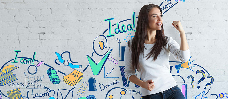 White female entrepreneur smiling in front of wall of business words, images