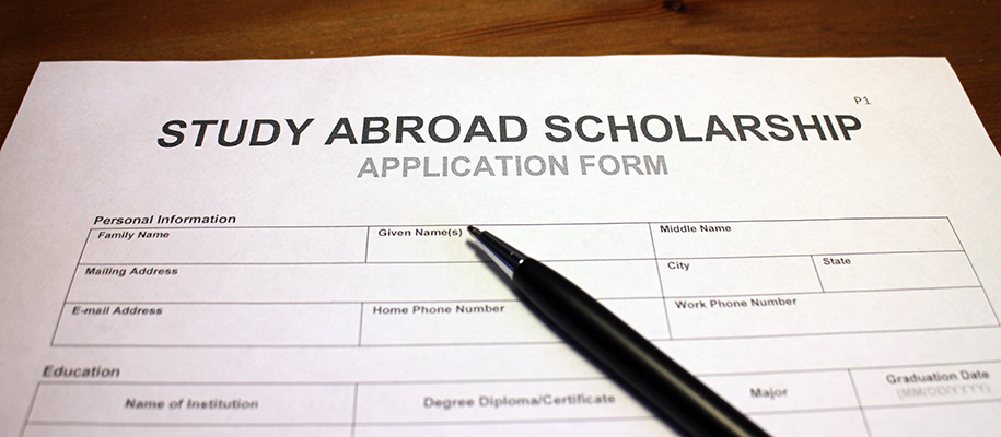 Study abroad scholarship application form with a black pen resting on top