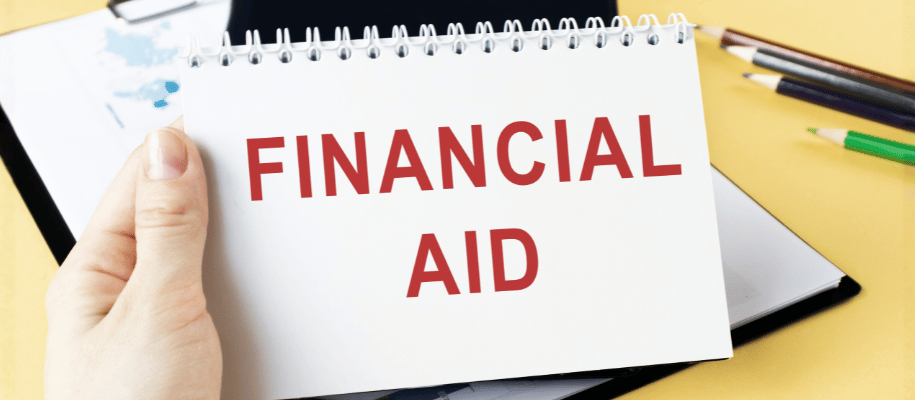 A hand holds a notepad with Financial Aid typed on the page
