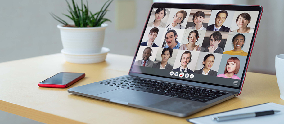 Diverse group of people on business video call on computer at desk with phone an