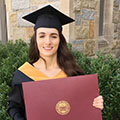 woman with brown hair in grad cap holding degree