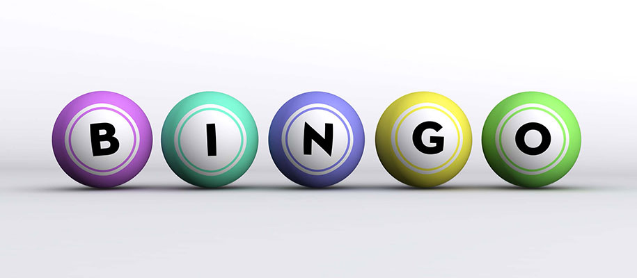 Five pastel-colored Bingo balls reading B-I-N-G-O sitting on white surface