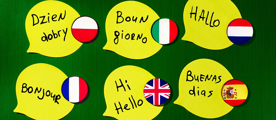 Yellow talk bubbles with flag stickers and Hello written in foreign languages