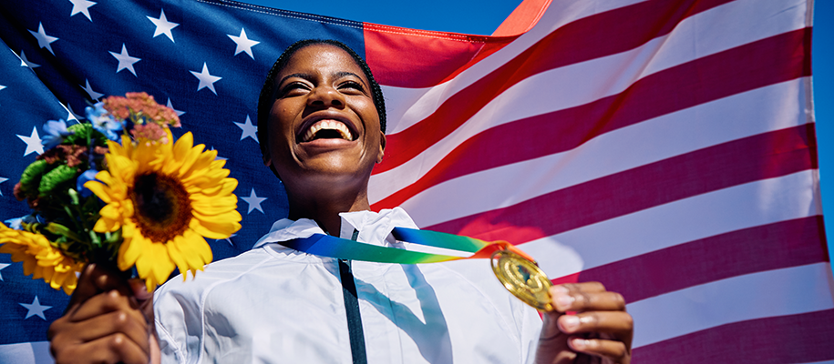 Black female Olympian with gold medal and sunflowers against American flag