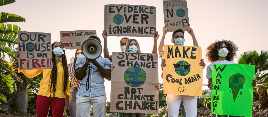 Group of young environmental protesters wearing masks and holding homemade signs