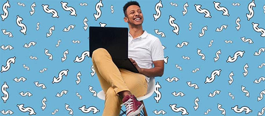 Smiling Black man sitting in chair with laptop with white cartoon dollar signs