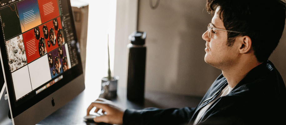 A man sitting at computer looking at various layouts on the screen