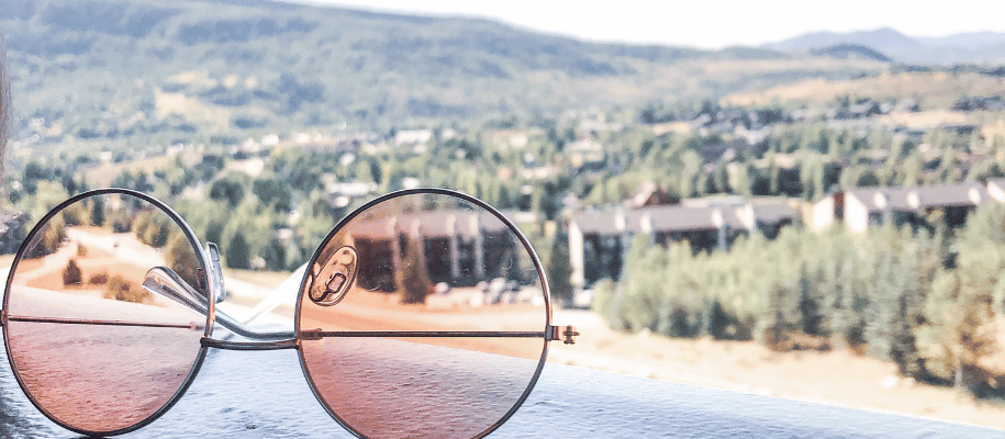 Close up of rose-colored glasses overlooking a campus