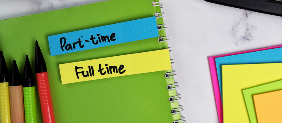 Green notebook with sticky notes reading part-time, full-time next to pencils