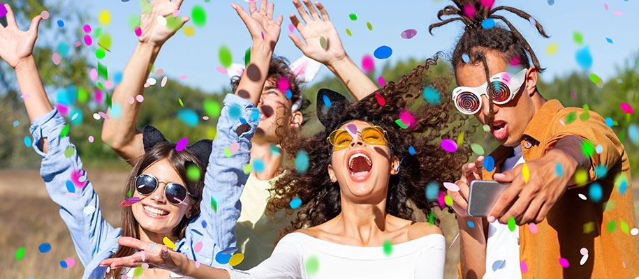 Excited and diverse group of college students with hands and confetti in the air