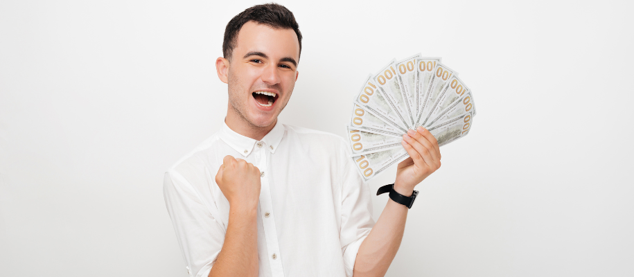 Young man in white button up, fist up in excitement, other hand full of cash