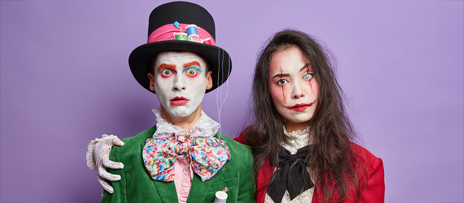 Man in Mad Hatter costume and woman in creepy ring master costume