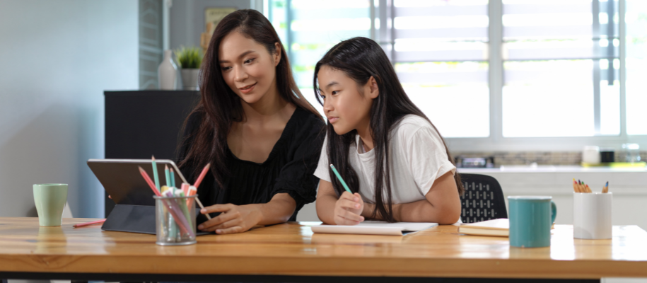 Young Asian woman with Asian counselor looking at table with notebook