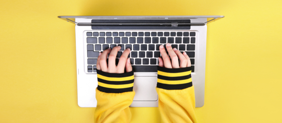 Brown-haired woman resting arms on book and face on hands in classroom