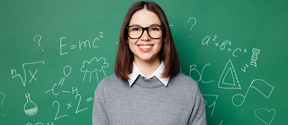 White teen in collared sweater, glasses against chalkboard with science symbols