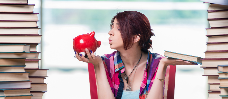 Girl in plaid holding book, piggy bank, making kissy face with stacks of books